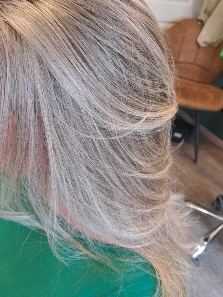 Lang blond haar met lichte highlights in laagjes, van dichtbij