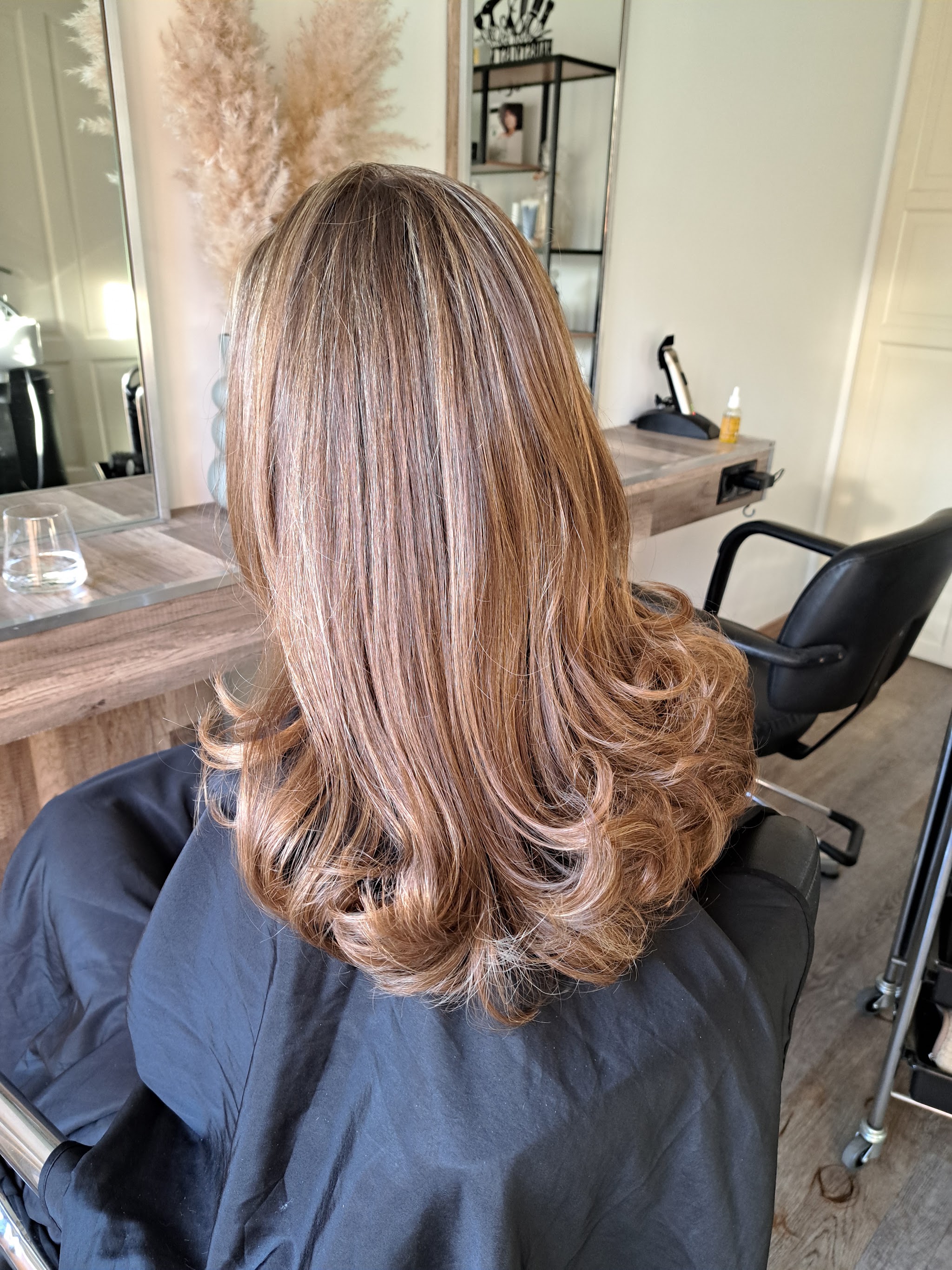 Warm blond haar met krullen, gezien in de salonstoel